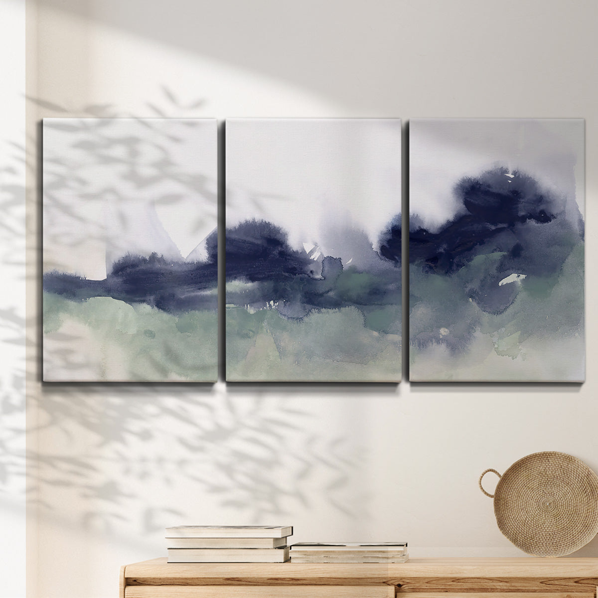 Three-panel canvas wall art featuring misty abstract lake watercolor, displayed in a minimalist living room above a console table.