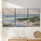 Three-panel canvas wall art featuring soft morning light over calm sea, displayed in a minimalist living room above a console table.