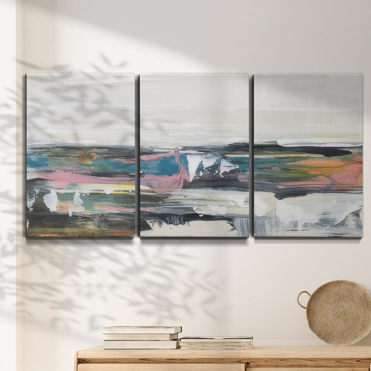 Three-panel canvas wall art featuring cheerful abstract coastal seascape, displayed in a minimalist living room above a console table.