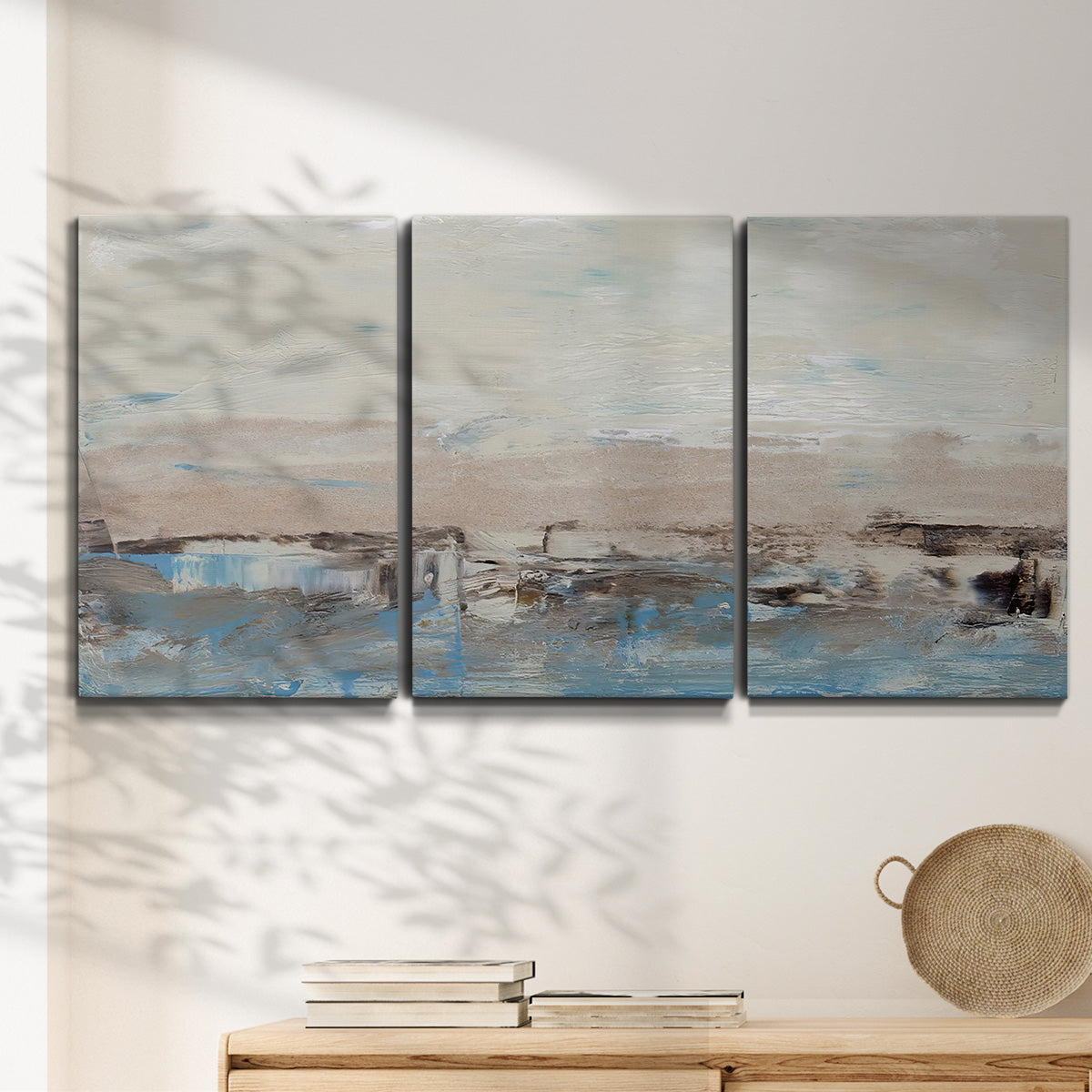 Three-panel canvas wall art featuring abstract bridge landscape in cyan, displayed in a minimalist living room above a console table.