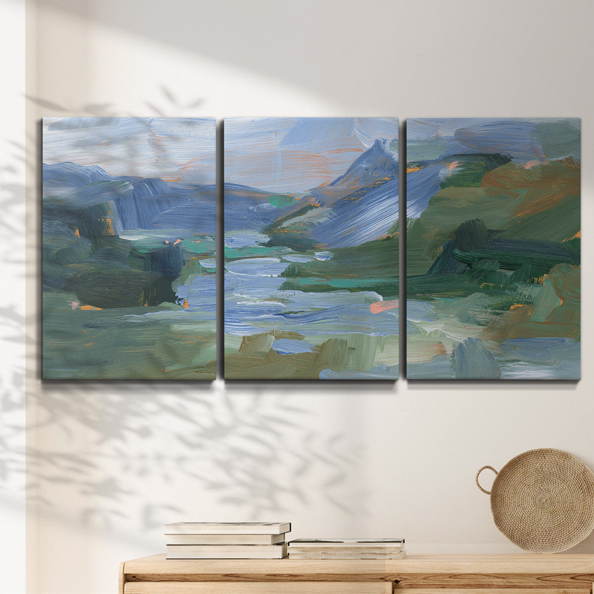 Three-panel canvas wall art featuring abstract landscape composition study, displayed in a minimalist living room above a console table.