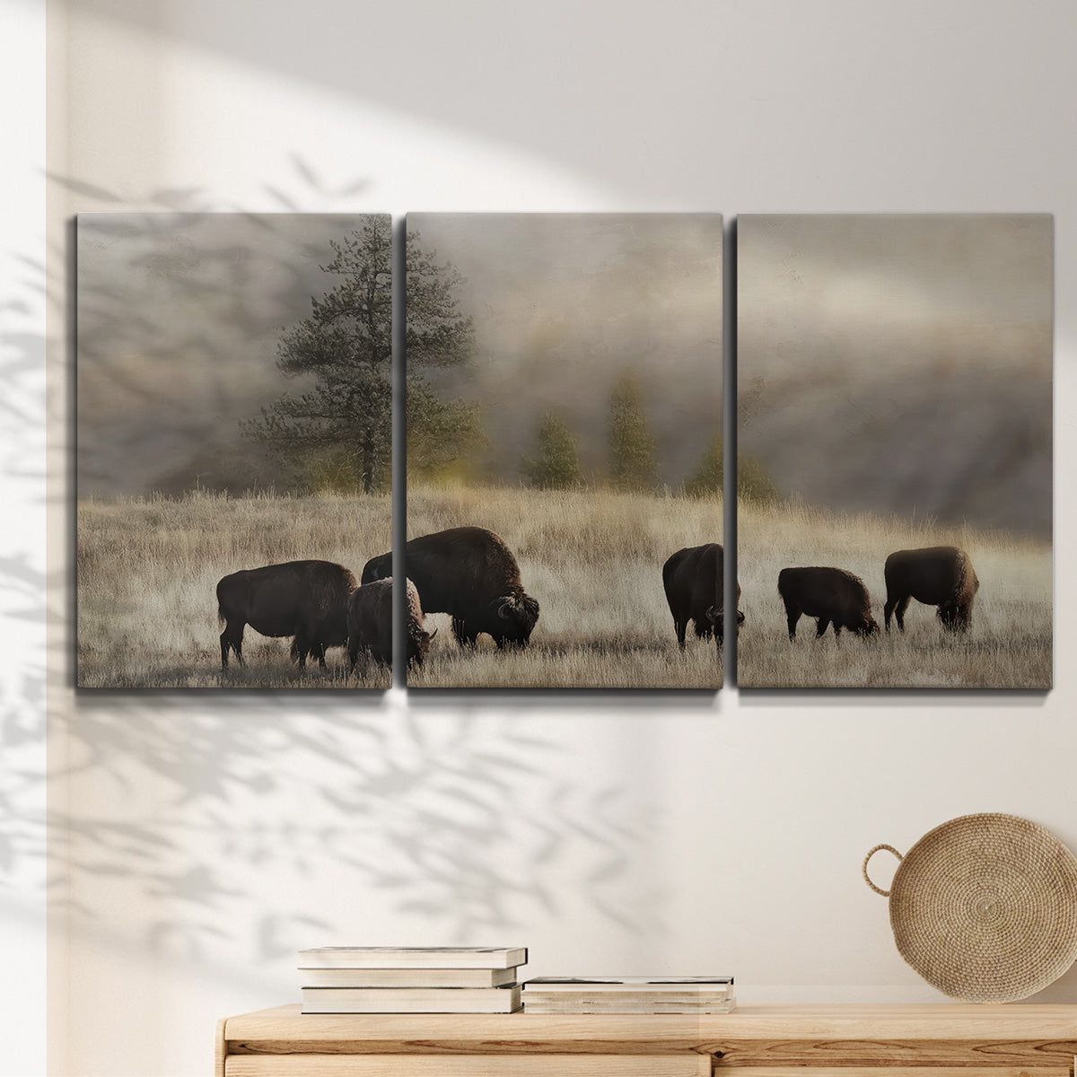 Three-panel canvas wall art featuring cattle grazing along ridge line, displayed in a minimalist living room above a console table.