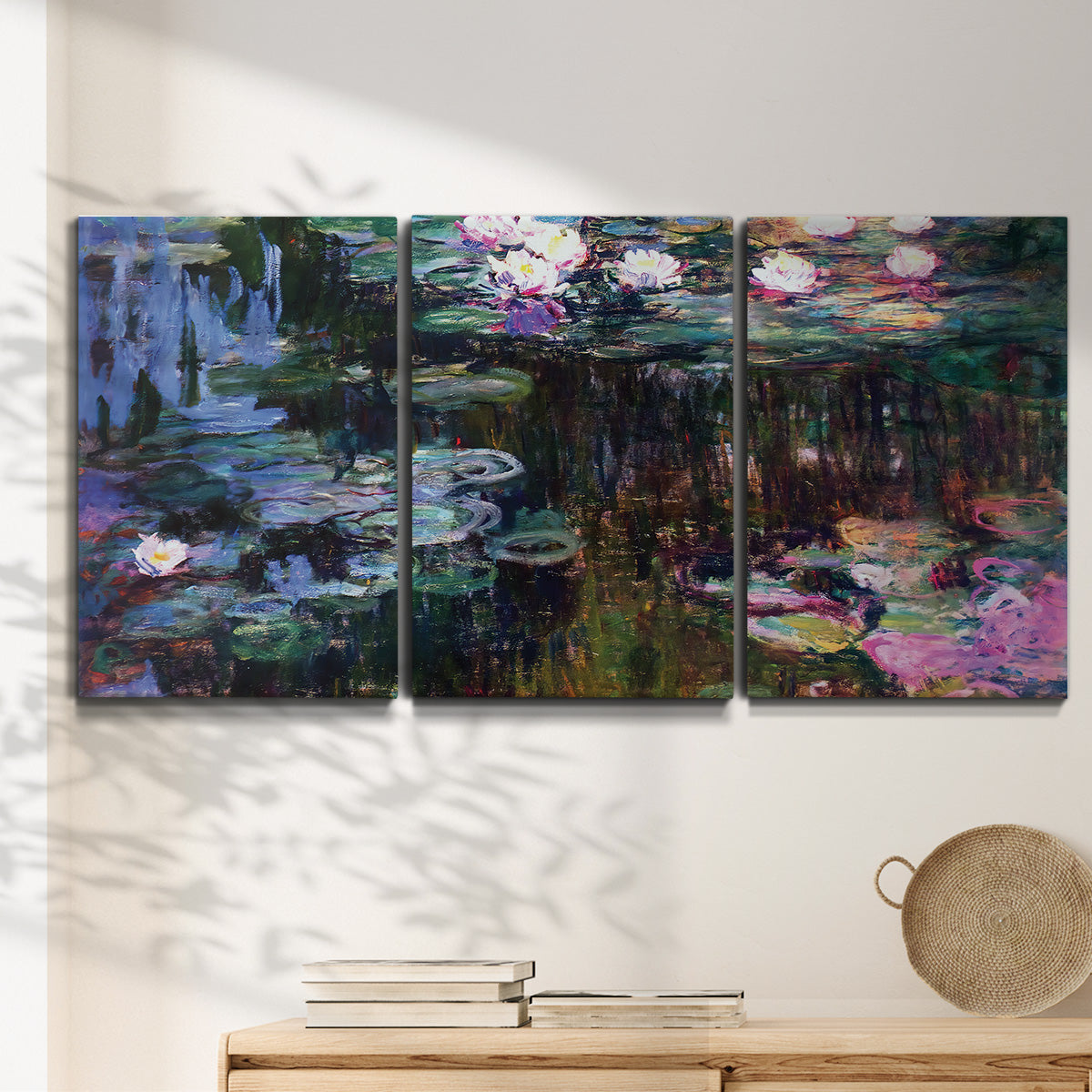 Three-panel canvas wall art featuring water lilies with willow reflections, displayed in a minimalist living room above a console table.