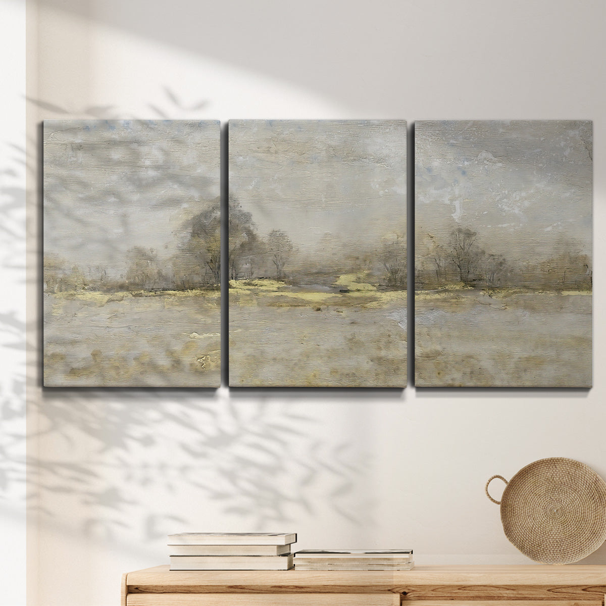 Three-panel canvas wall art featuring late season rural harvest fields, displayed in a minimalist living room above a console table.