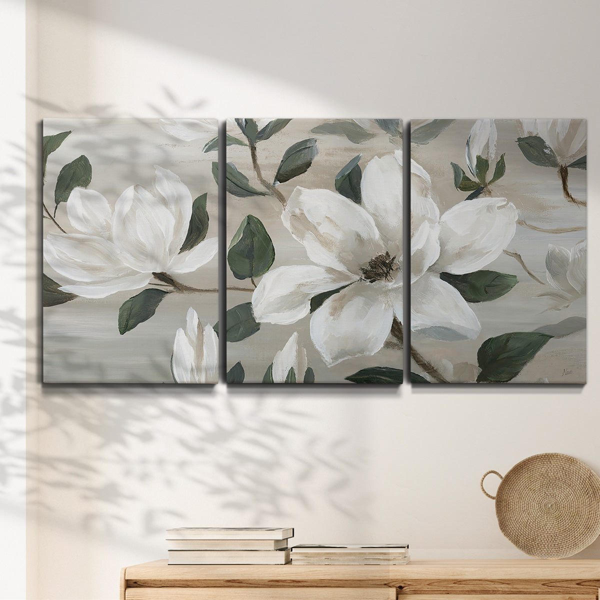 Three-panel canvas wall art featuring soft southern floral charm, displayed in a minimalist living room above a console table.