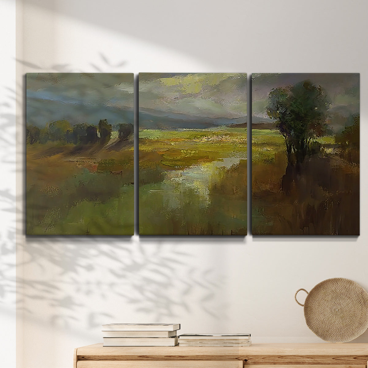 Three-panel canvas wall art featuring winding rural road through countryside, displayed in a minimalist living room above a console table.