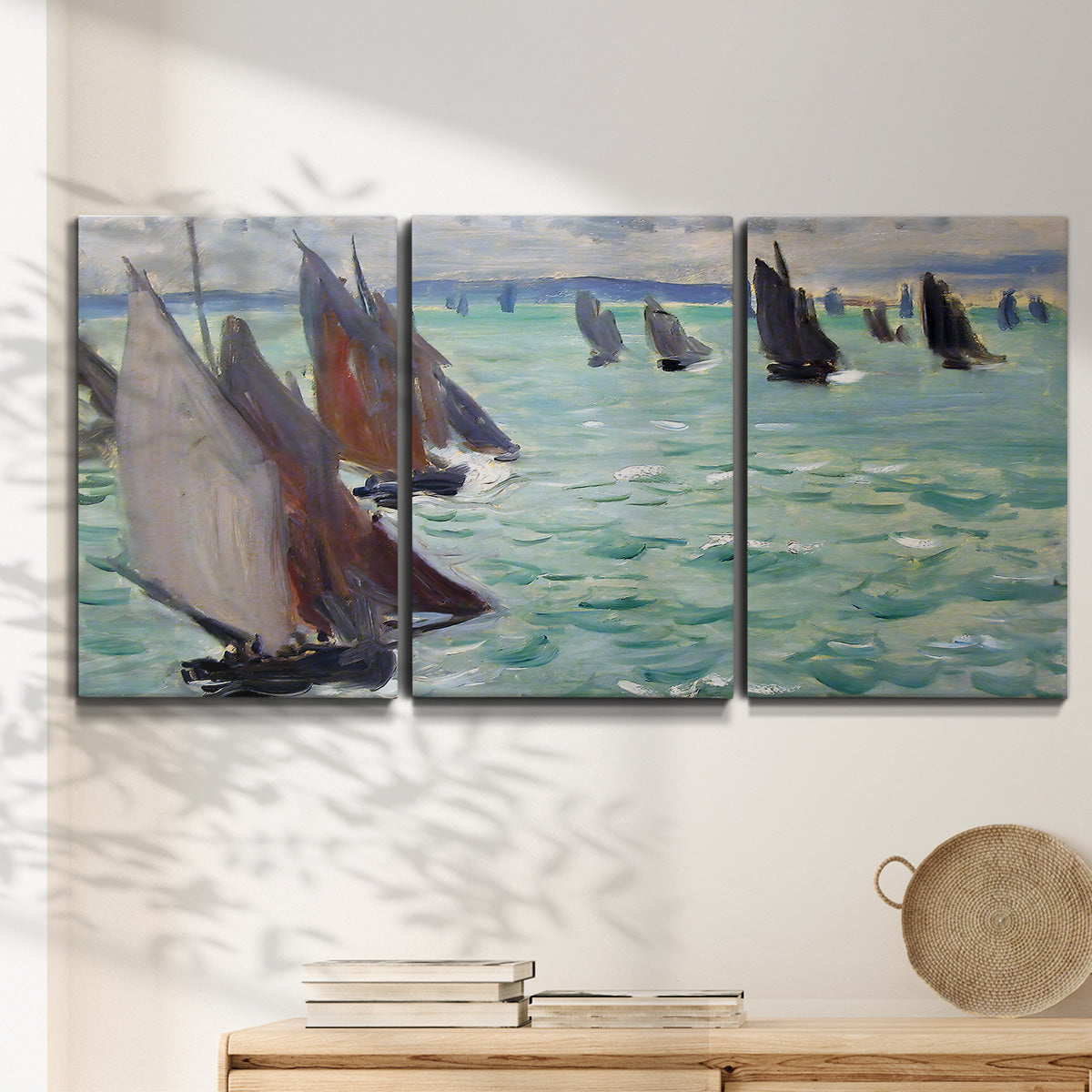 Three-panel canvas wall art featuring sailboat regatta near coastal village, displayed in a minimalist living room above a console table.
