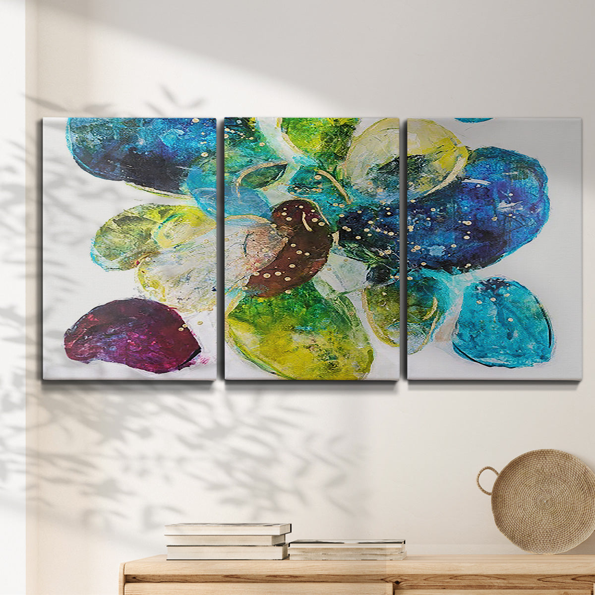 Three-panel canvas wall art featuring expressive abstract color interpretations, displayed in a minimalist living room above a console table.