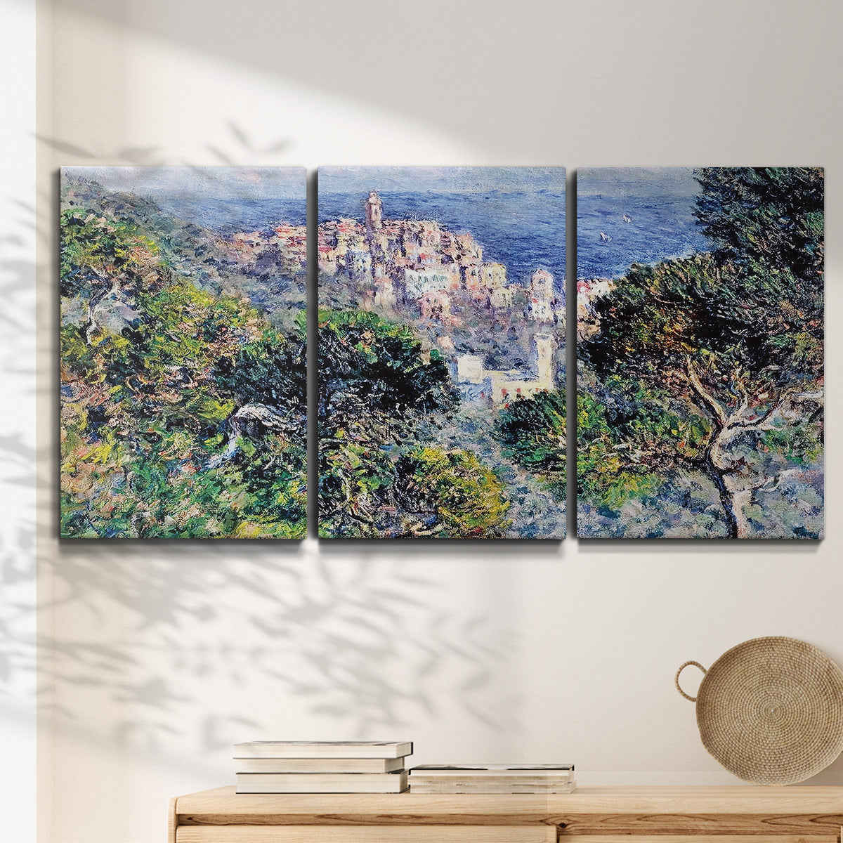Three-panel canvas wall art featuring coastal hillside overlooking monaco, displayed in a minimalist living room above a console table.