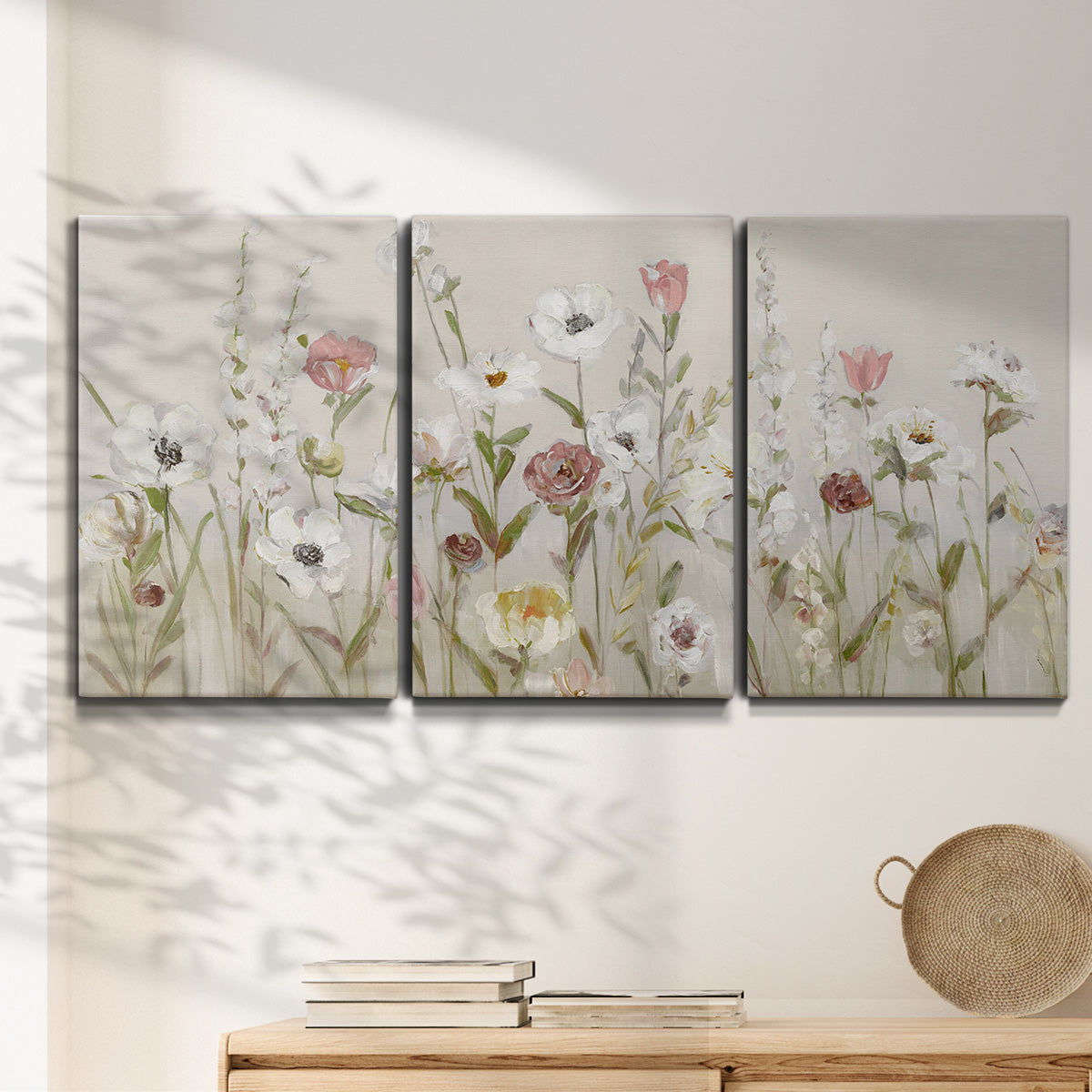 Three-panel canvas wall art featuring loose farmhouse style floral painting, displayed in a minimalist living room above a console table.