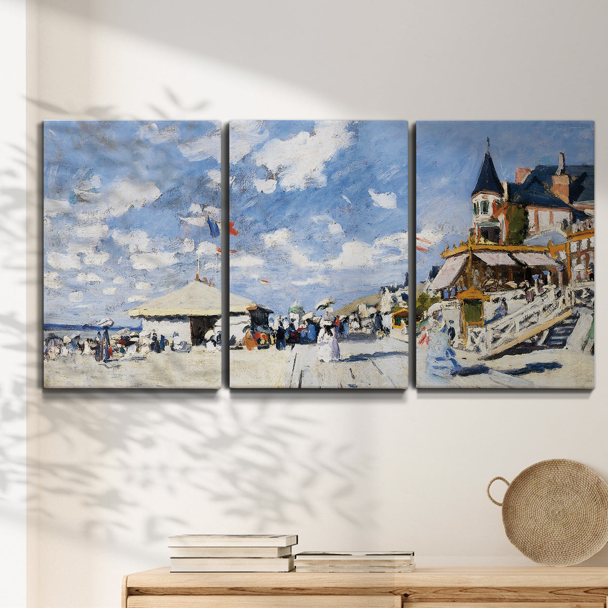 Three-panel canvas wall art featuring beach boardwalk with figures, displayed in a minimalist living room above a console table.