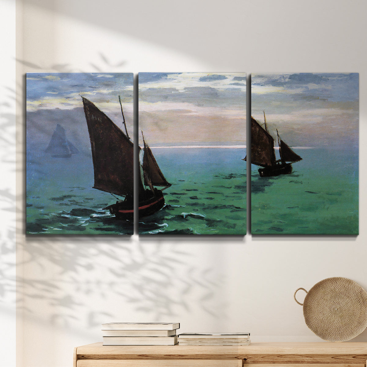 Three-panel canvas wall art featuring fishing boats moving through open sea, displayed in a minimalist living room above a console table.