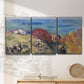 Three-panel canvas wall art featuring coastal village shoreline landscape, displayed in a minimalist living room above a console table.