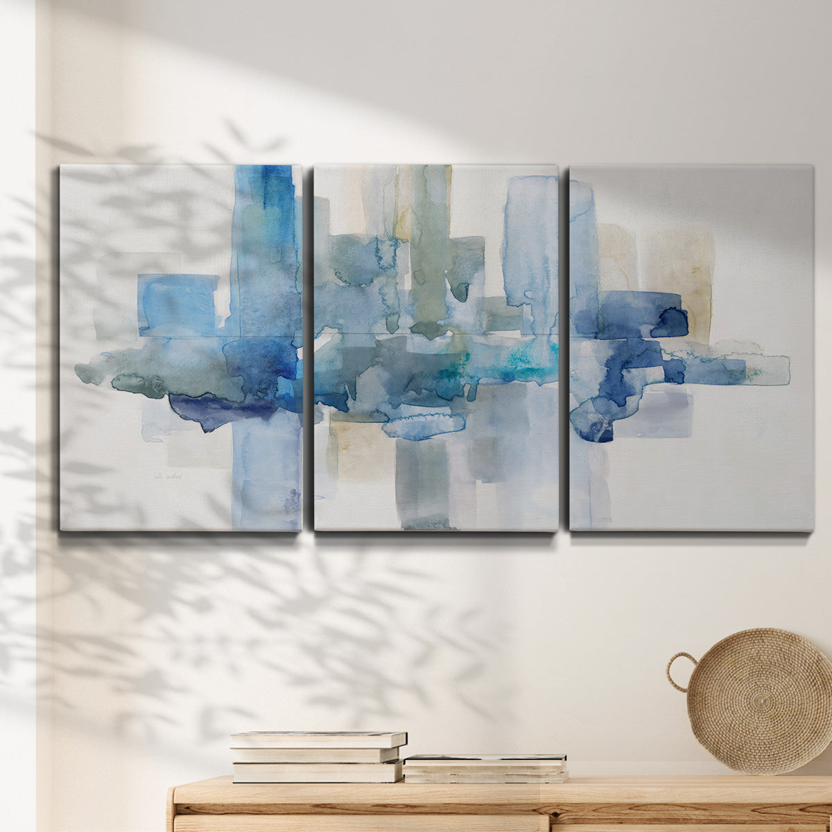 Three-panel canvas wall art featuring minimal urban skyline watercolor, displayed in a minimalist living room above a console table.