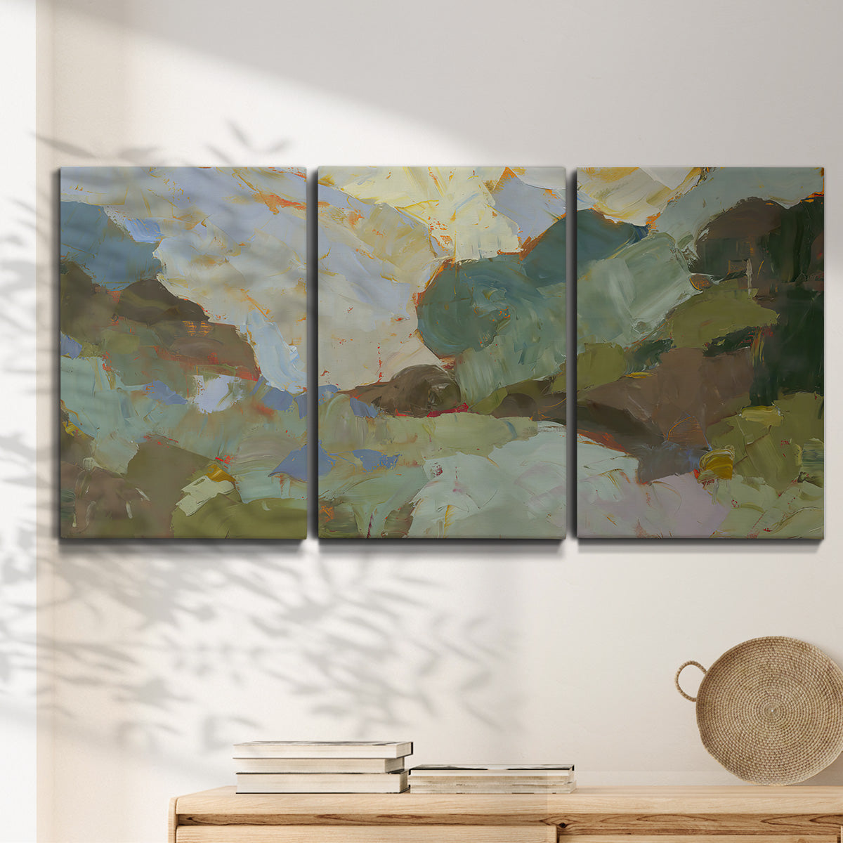 Three-panel canvas wall art featuring abstract landscape suggesting travel pause, displayed in a minimalist living room above a console table.