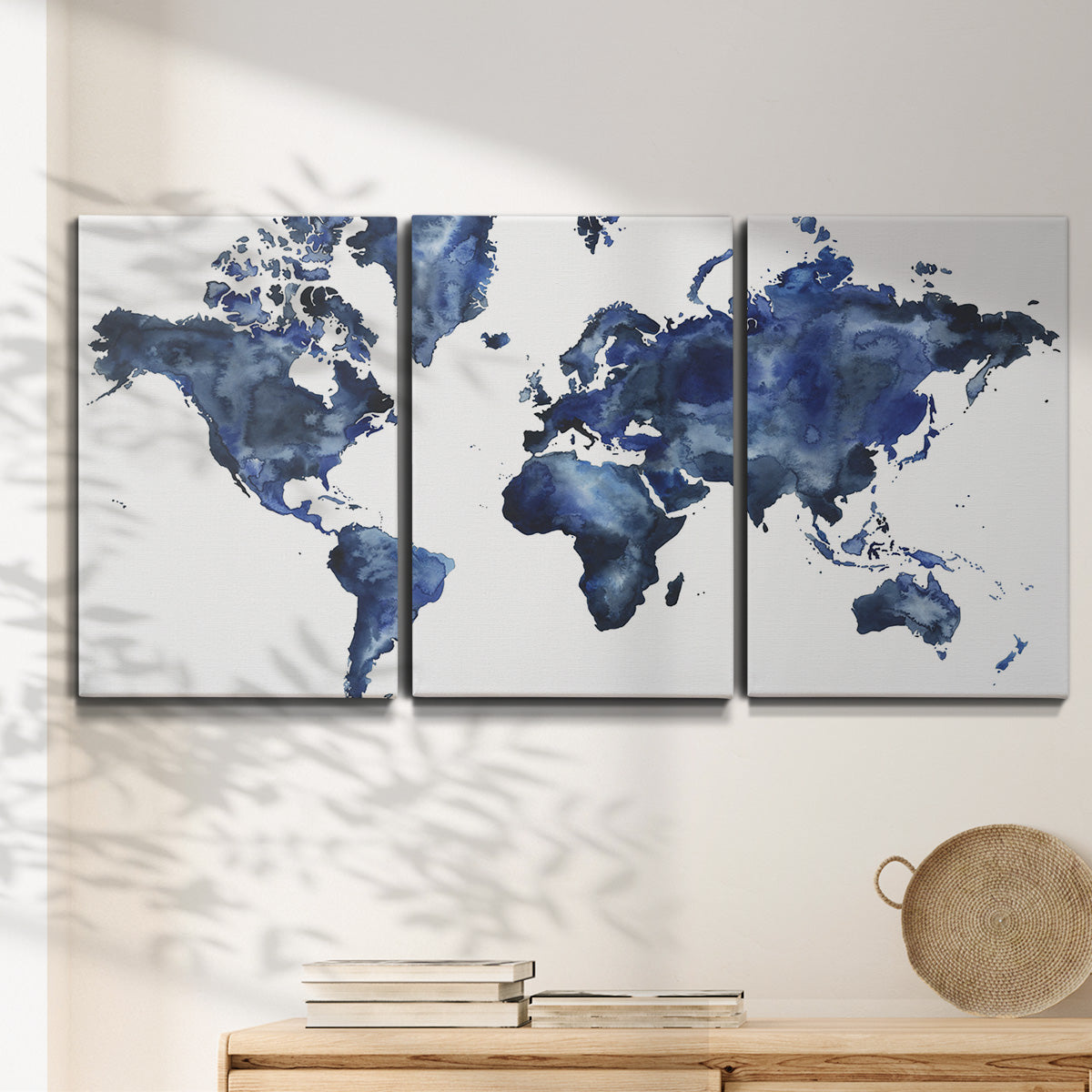 Three-panel canvas wall art featuring world map with water motif, displayed in a minimalist living room above a console table.