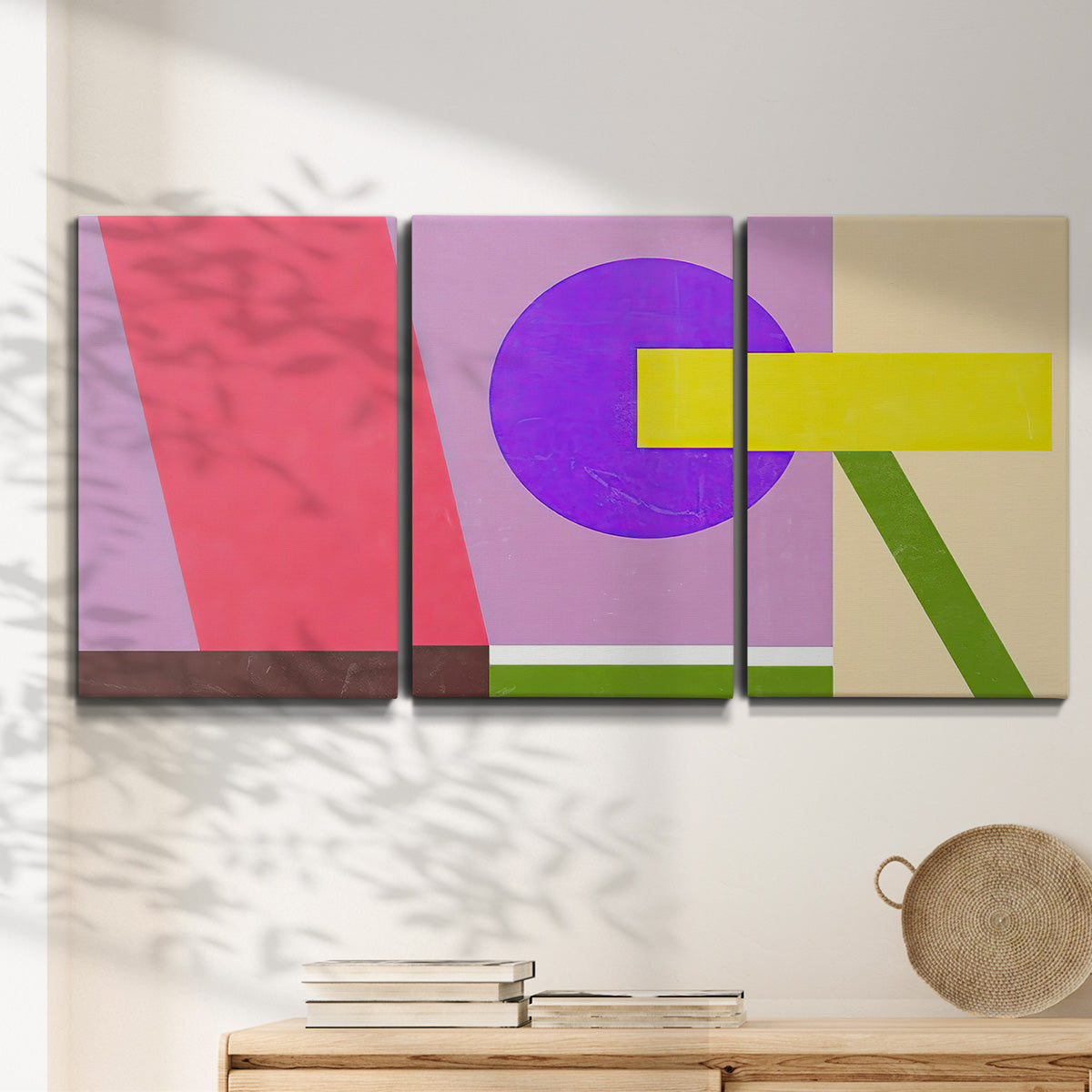 Three-panel canvas wall art featuring bold geometric color abstraction, displayed in a minimalist living room above a console table.