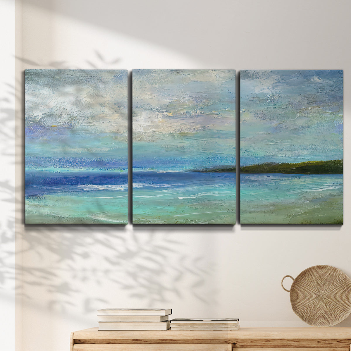 Three-panel canvas wall art featuring narrow island inlet waters, displayed in a minimalist living room above a console table.