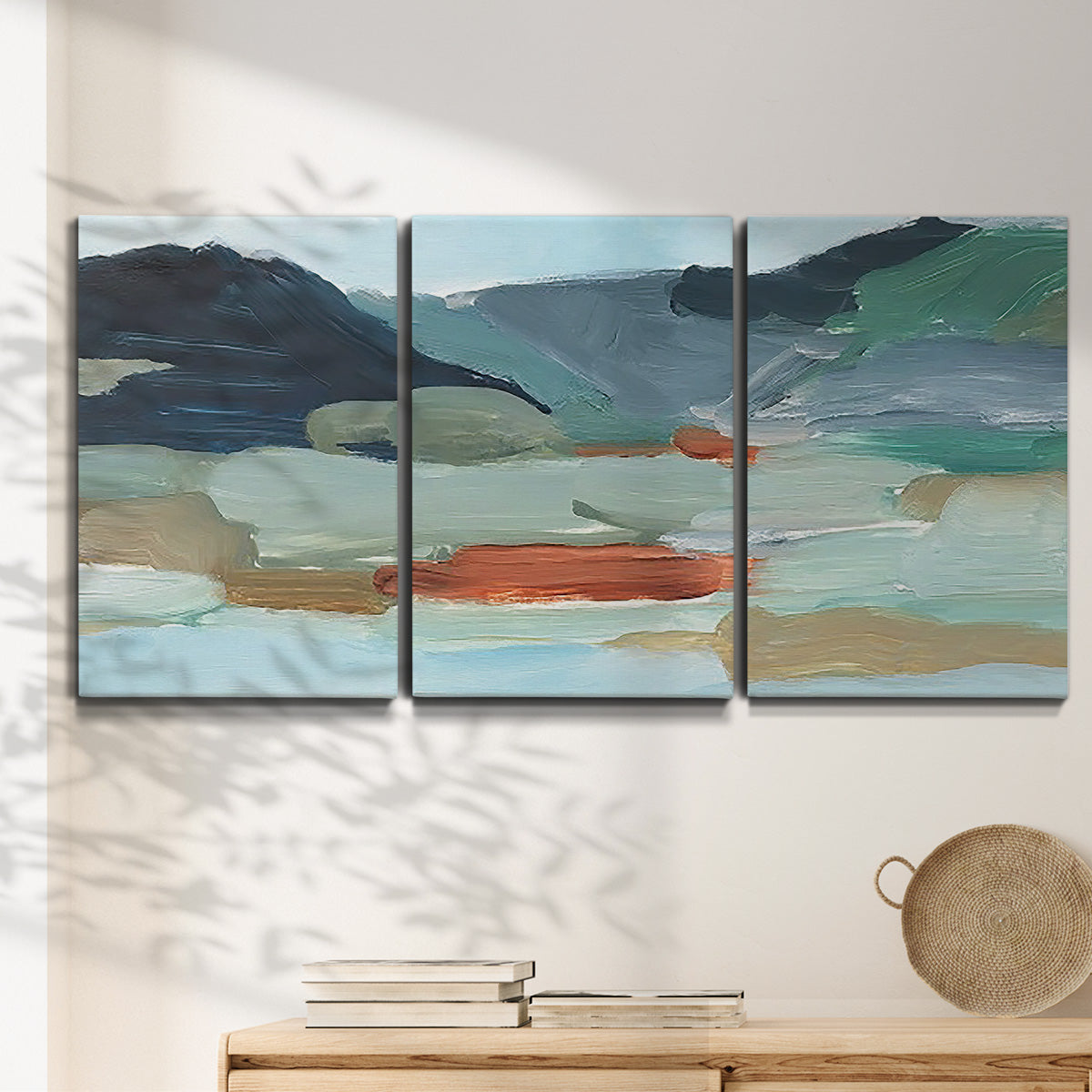 Three-panel canvas wall art featuring vibrant abstract with dramatic motion, displayed in a minimalist living room above a console table.