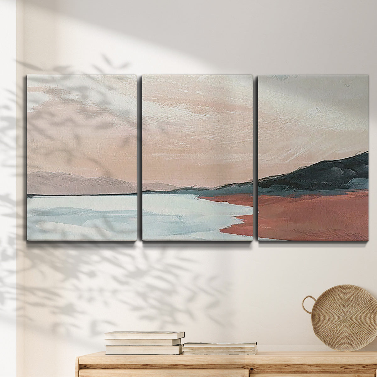 Three-panel canvas wall art featuring quiet coastline with distant horizon, displayed in a minimalist living room above a console table.