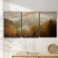 Three-panel canvas wall art featuring misty autumn landscape photograph, displayed in a minimalist living room above a console table.
