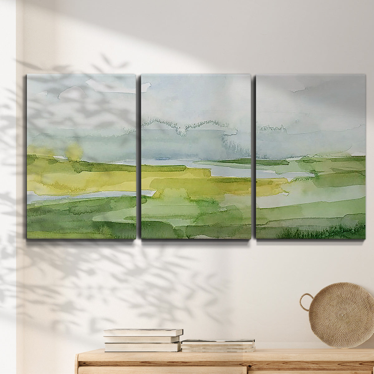 Three-panel canvas wall art featuring lowland wetlands with reflective water, displayed in a minimalist living room above a console table.