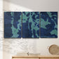 Three-panel canvas wall art featuring abstract floral shapes, displayed in a minimalist living room above a console table.
