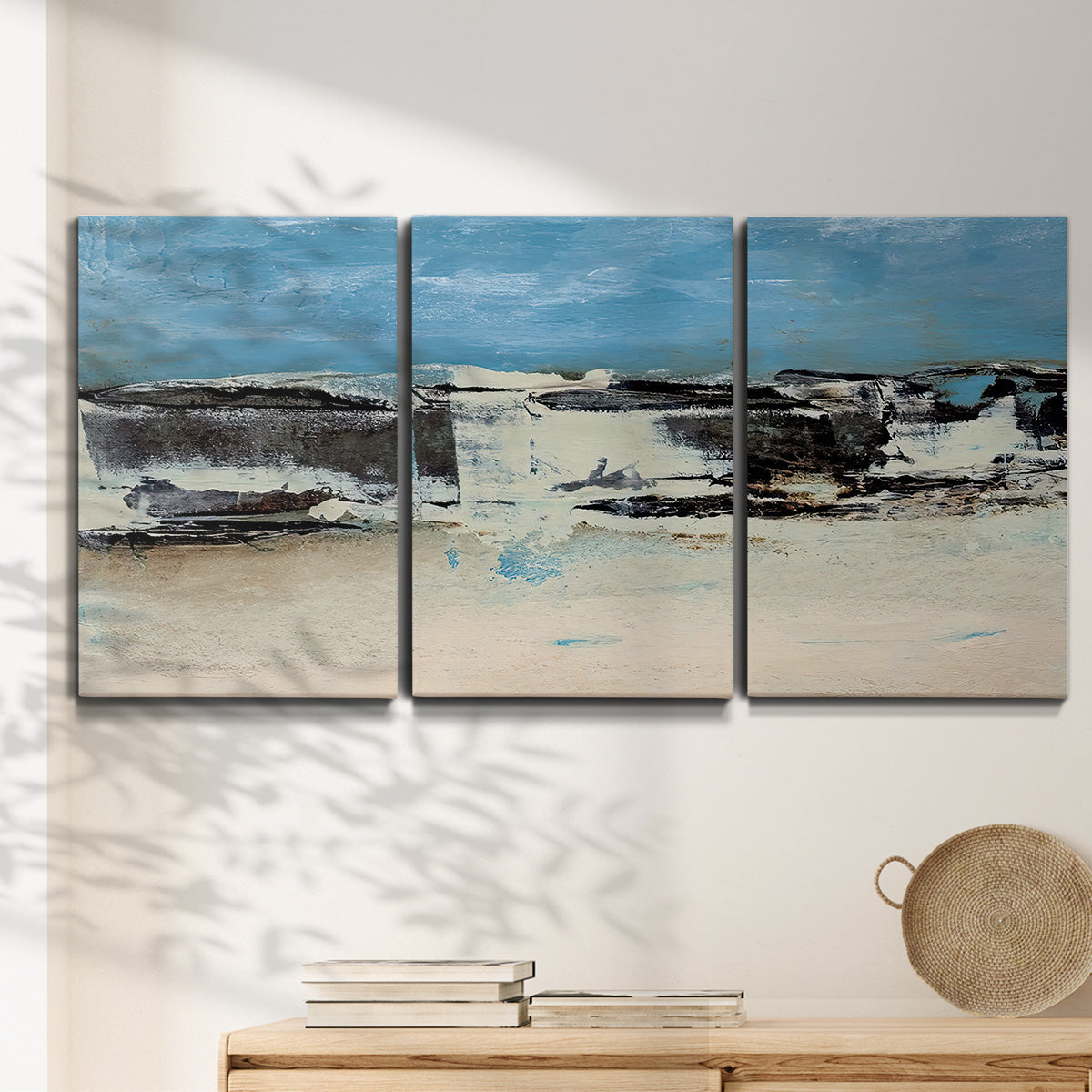 Three-panel canvas wall art featuring abstract bridge landscape in cyan, displayed in a minimalist living room above a console table.