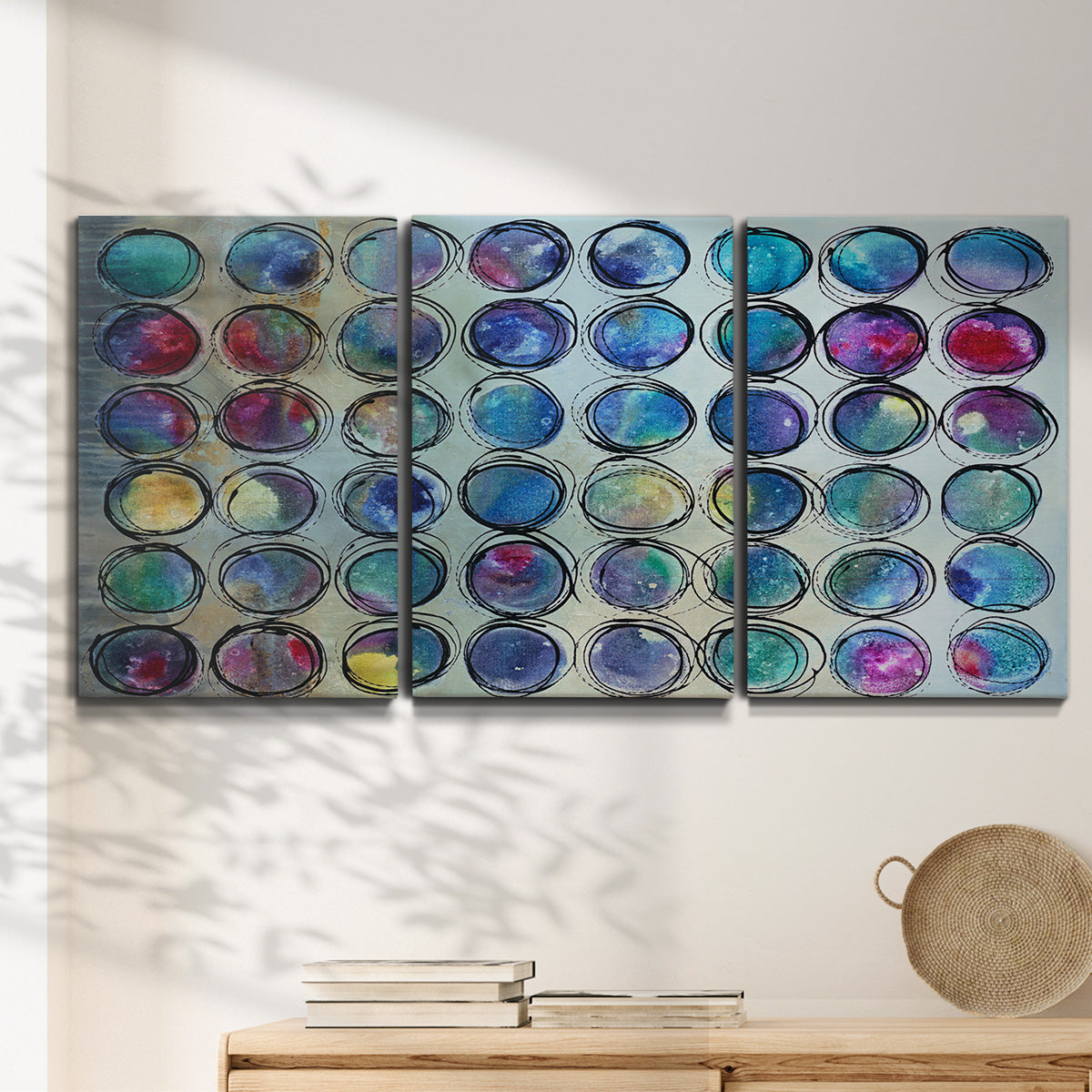 Three-panel canvas wall art featuring contrasting geometric abstract variations, displayed in a minimalist living room above a console table.