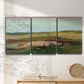 Three-panel canvas wall art featuring pastoral landscape with winding road, displayed in a minimalist living room above a console table.
