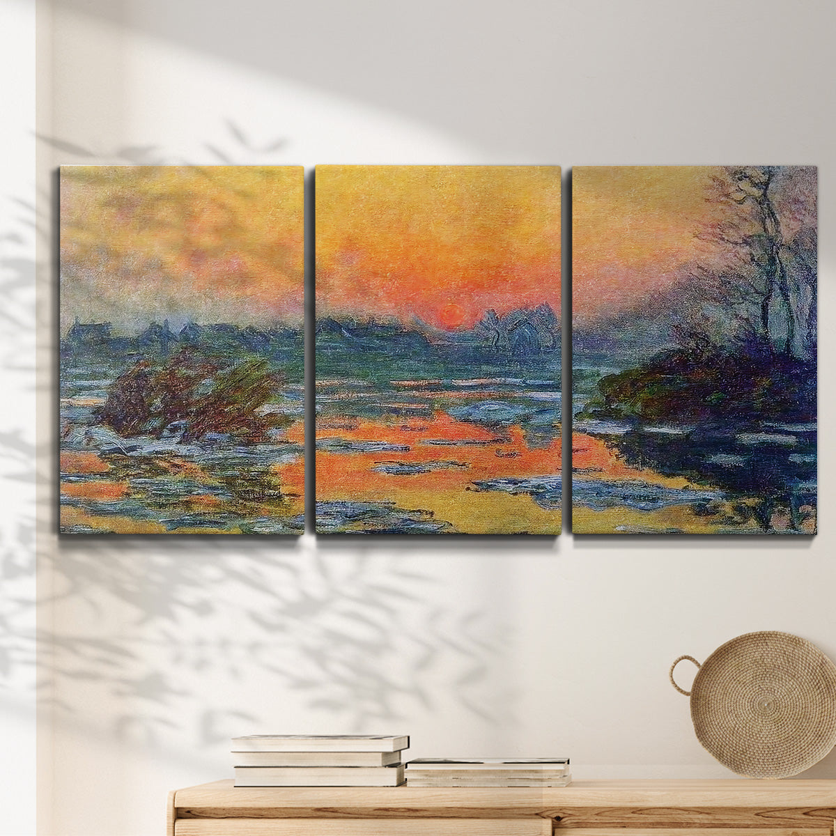 Three-panel canvas wall art featuring winter sunset over river, displayed in a minimalist living room above a console table.