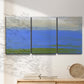 Three-panel canvas wall art featuring abstract coastal inlet landscape, displayed in a minimalist living room above a console table.