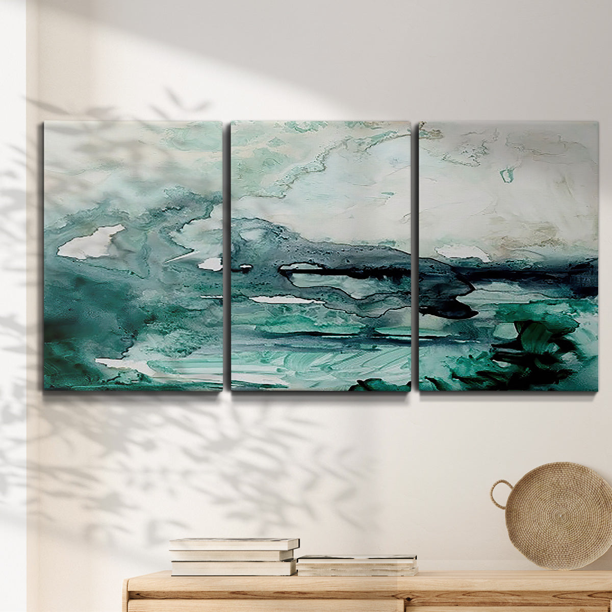 Three-panel canvas wall art featuring coastal abstract sea foam movement, displayed in a minimalist living room above a console table.
