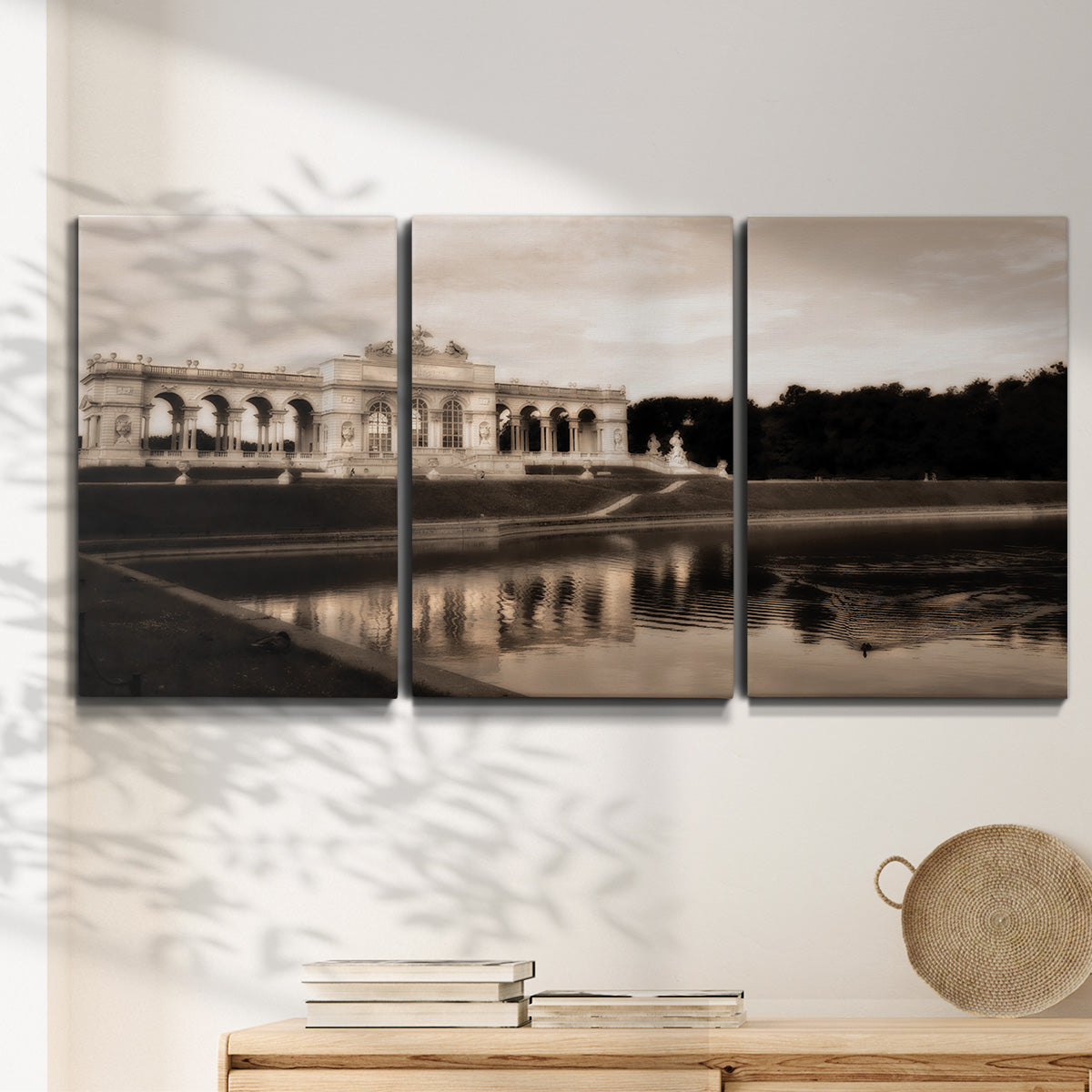 Three-panel canvas wall art featuring monochrome historic pavilion photograph, displayed in a minimalist living room above a console table.