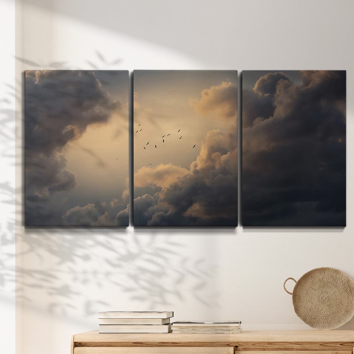 Three-panel canvas wall art featuring surreal floating figures above landscape, displayed in a minimalist living room above a console table.