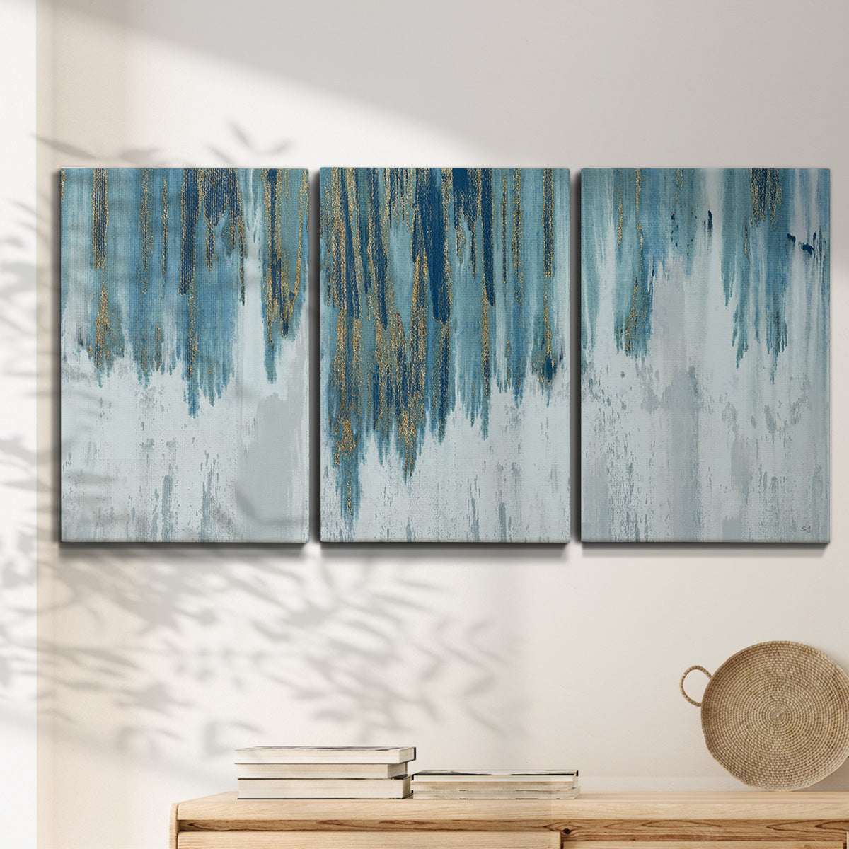 Three-panel canvas wall art featuring wide pastoral valley landscape, displayed in a minimalist living room above a console table.
