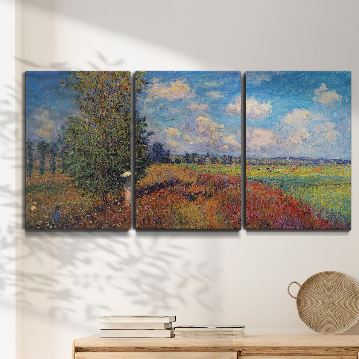 Three-panel canvas wall art featuring summer poppy field in bloom, displayed in a minimalist living room above a console table.