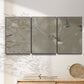 Three-panel canvas wall art featuring mid century terrazzo inspired abstraction, displayed in a minimalist living room above a console table.