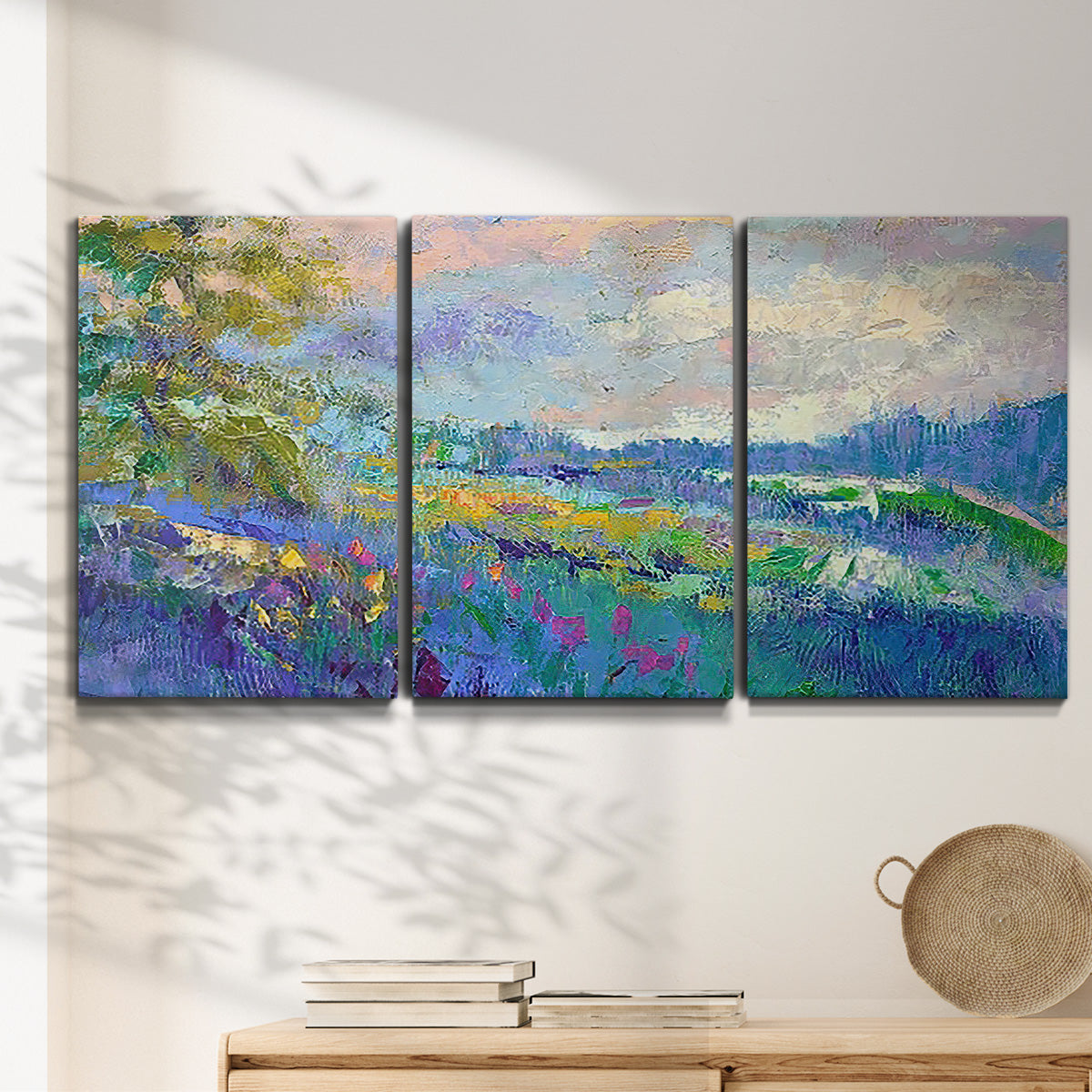Three-panel canvas wall art featuring cheerful landscape under open sky, displayed in a minimalist living room above a console table.