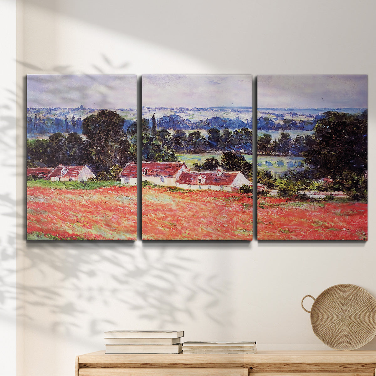 Three-panel canvas wall art featuring poppy field at giverny in bloom, displayed in a minimalist living room above a console table.