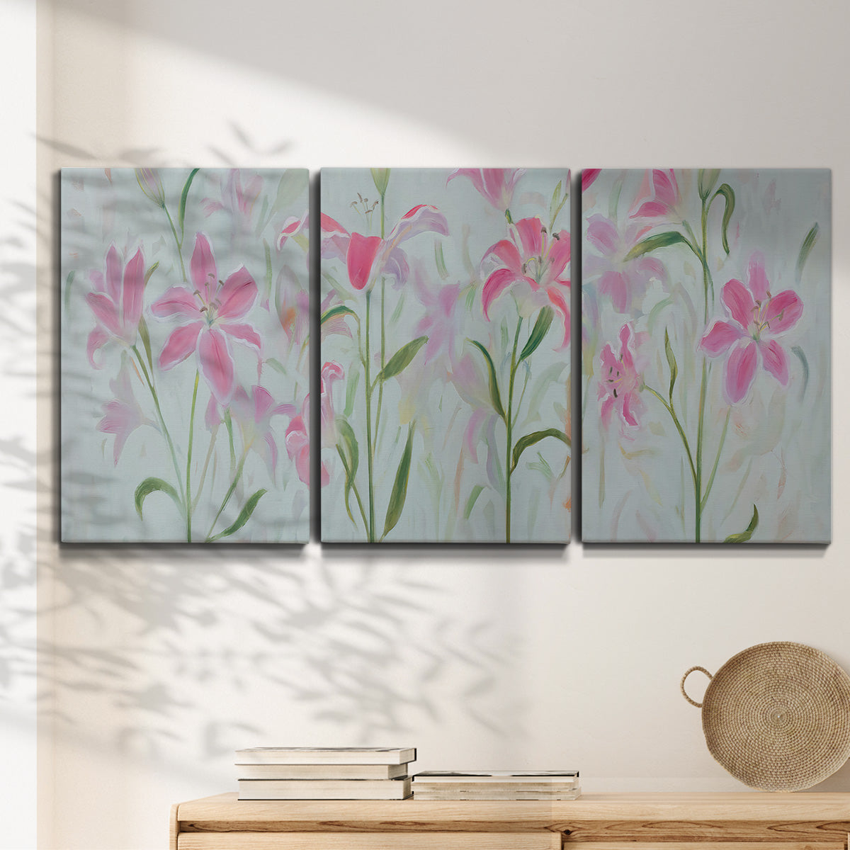 Three-panel canvas wall art featuring pink floral trio arrangement, displayed in a minimalist living room above a console table.