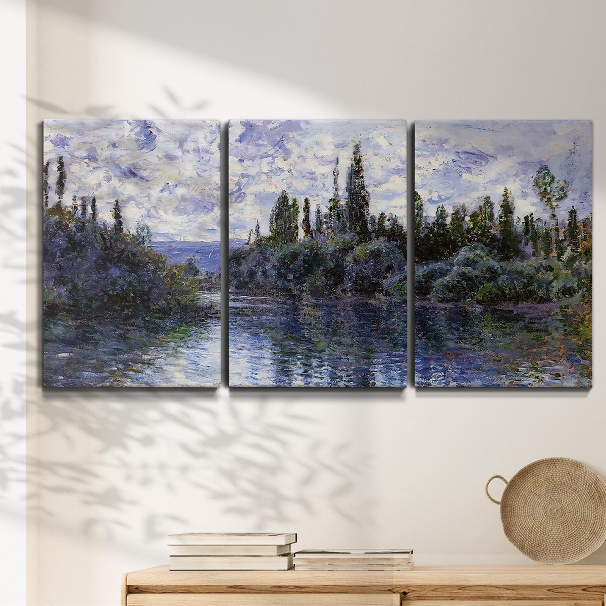 Three-panel canvas wall art featuring quiet river bend near village, displayed in a minimalist living room above a console table.