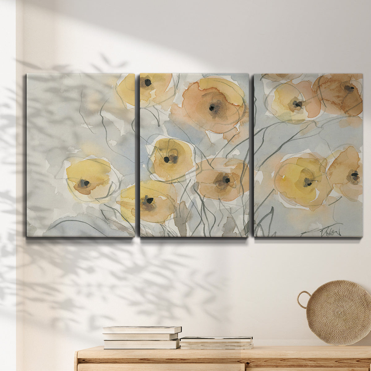 Three-panel canvas wall art featuring minimalist poppies at sunset, displayed in a minimalist living room above a console table.