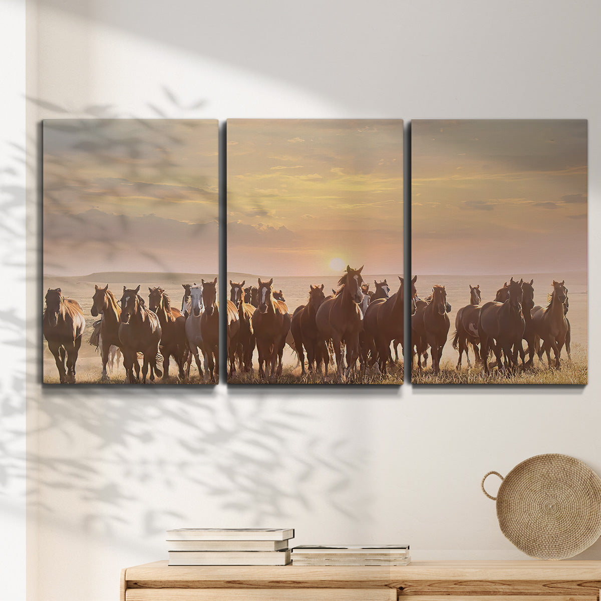 Three-panel canvas wall art featuring running horses captured in motion, displayed in a minimalist living room above a console table.