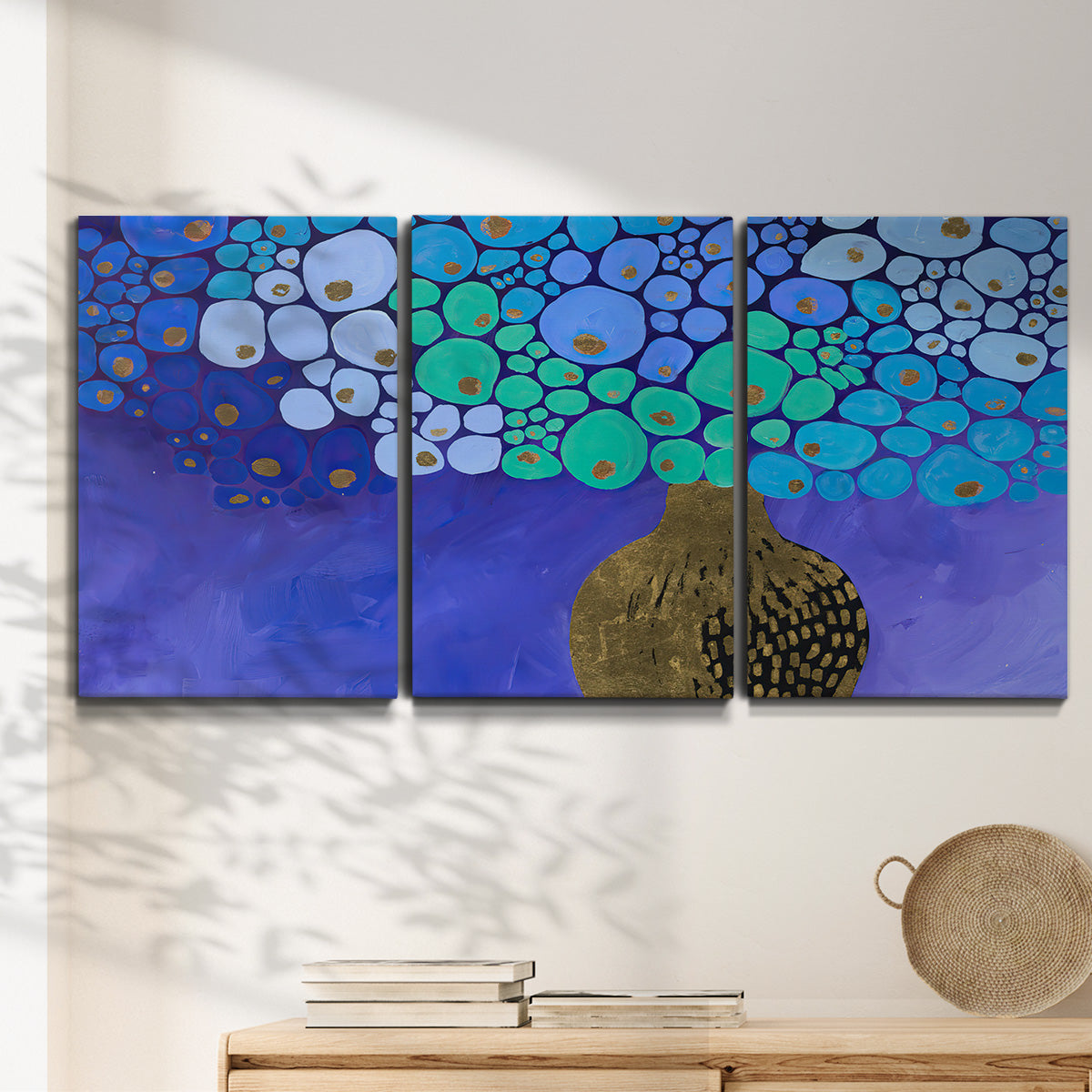 Three-panel canvas wall art featuring blue poppy floral abstraction, displayed in a minimalist living room above a console table.