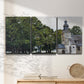 Three-panel canvas wall art featuring chapel building in rural setting, displayed in a minimalist living room above a console table.