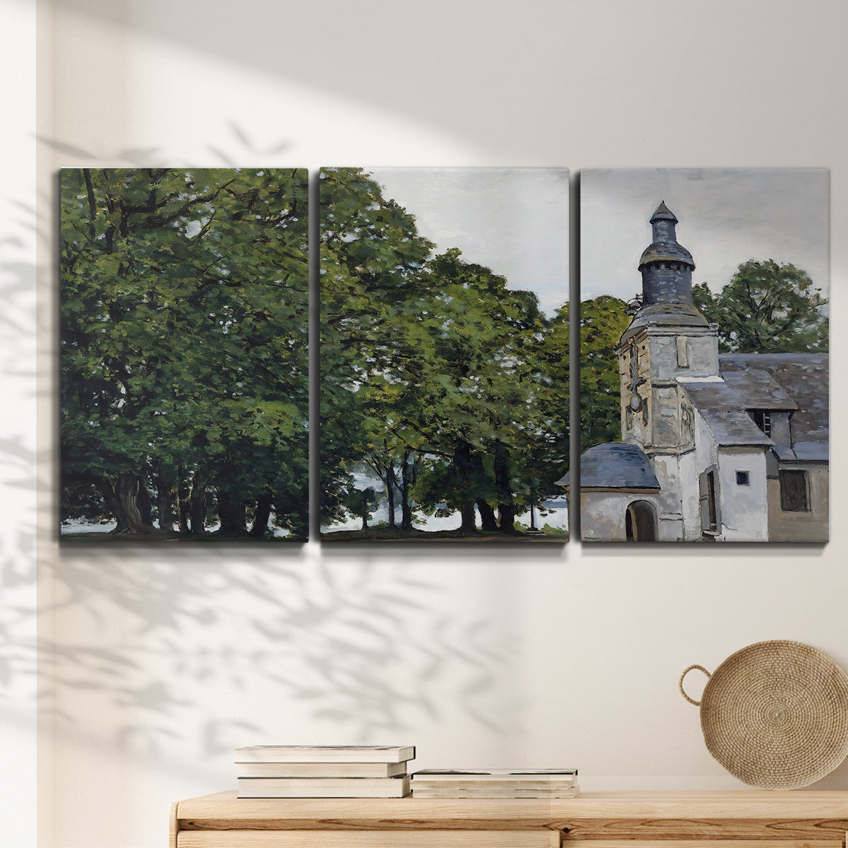 Three-panel canvas wall art featuring chapel building in rural setting, displayed in a minimalist living room above a console table.