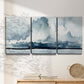 Three-panel canvas wall art featuring abstract rainstorm watercolor, displayed in a minimalist living room above a console table.