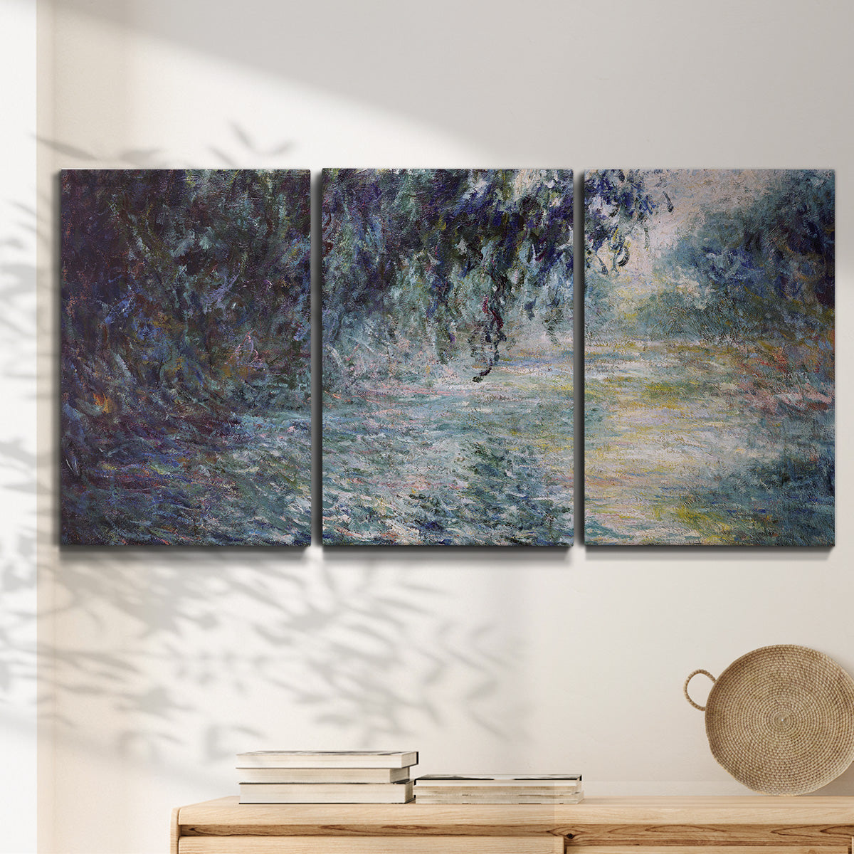 Three-panel canvas wall art featuring misty river scene in morning light, displayed in a minimalist living room above a console table.