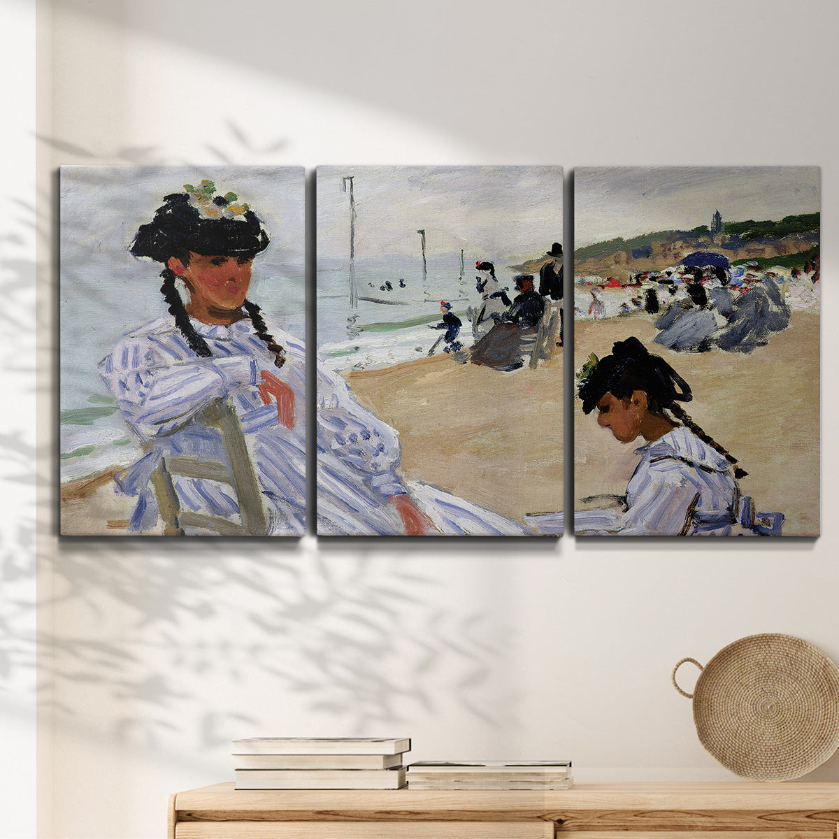 Three-panel canvas wall art featuring figures walking along sandy beach, displayed in a minimalist living room above a console table.
